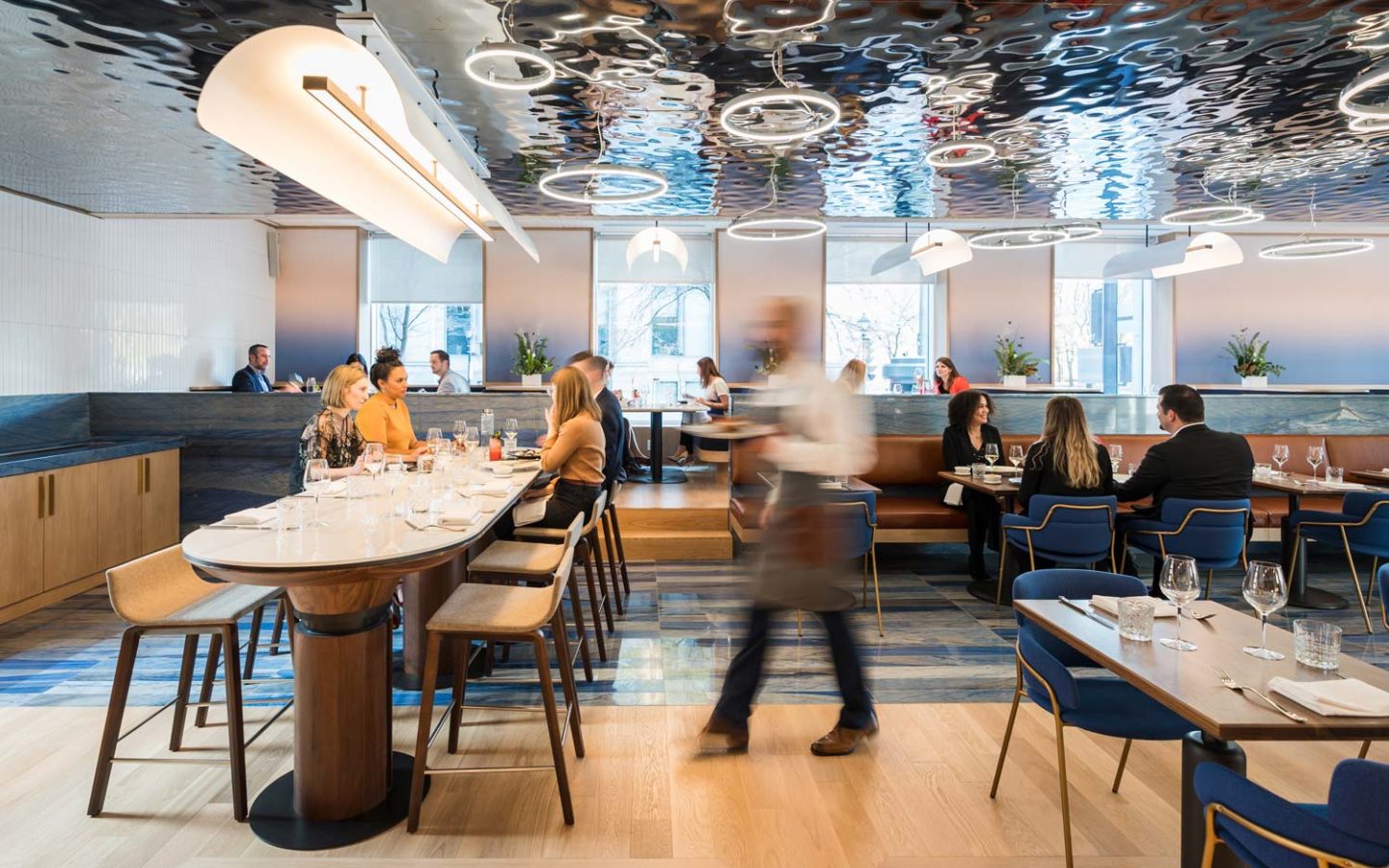 server walking through bustling restaurant interior