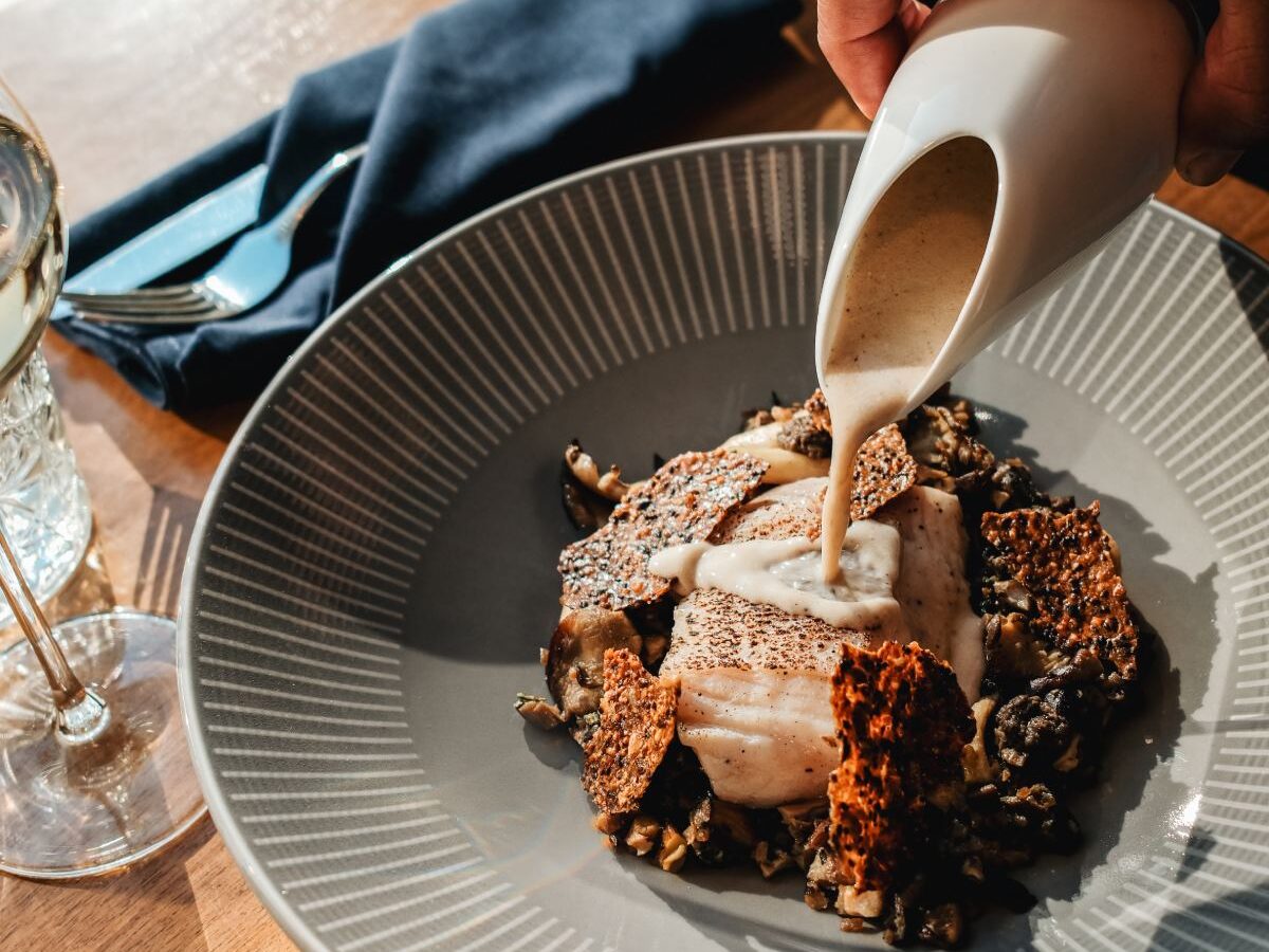 Sauce poured over an elegant plated dish.