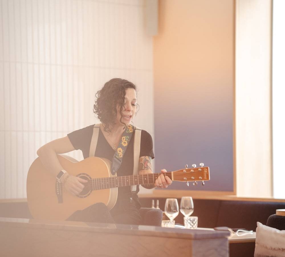 a woman playing a guitar in a restaurant
